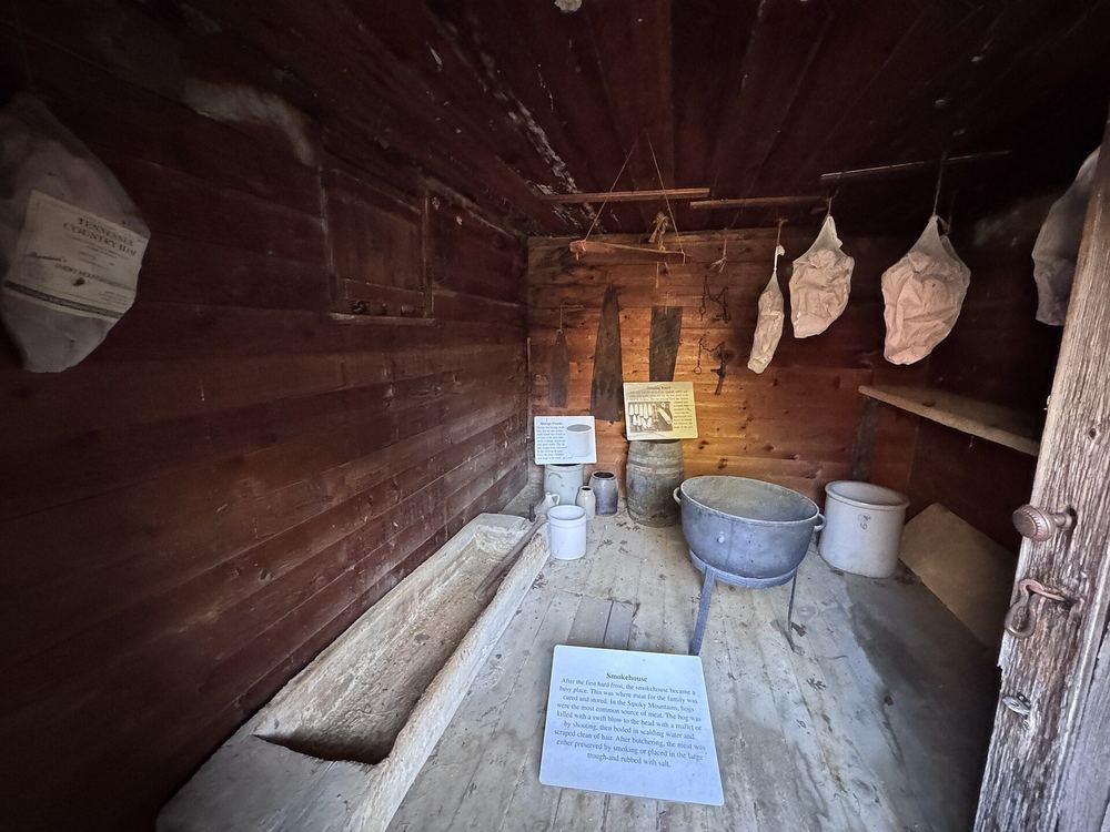 Meat hanging inside a wooden smokehouse